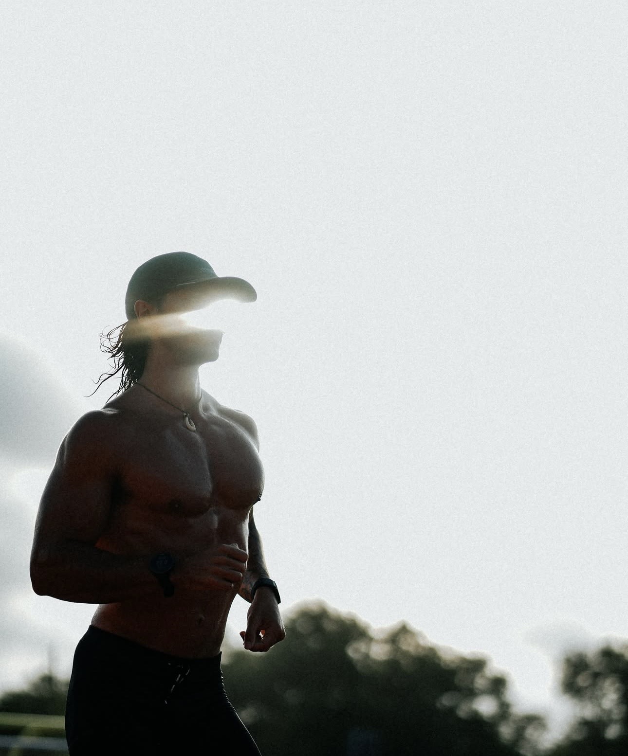 Fonz outdoors in running gear, backlit by the sun.